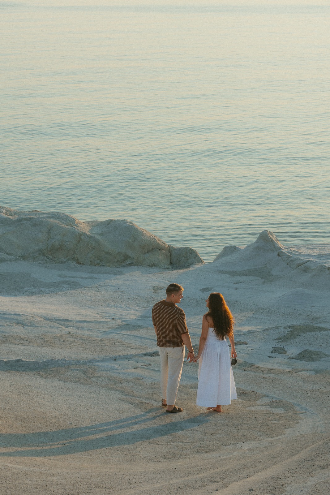 Couple at sunrise on Sarakiniko beach, photographed by a Milos photographer