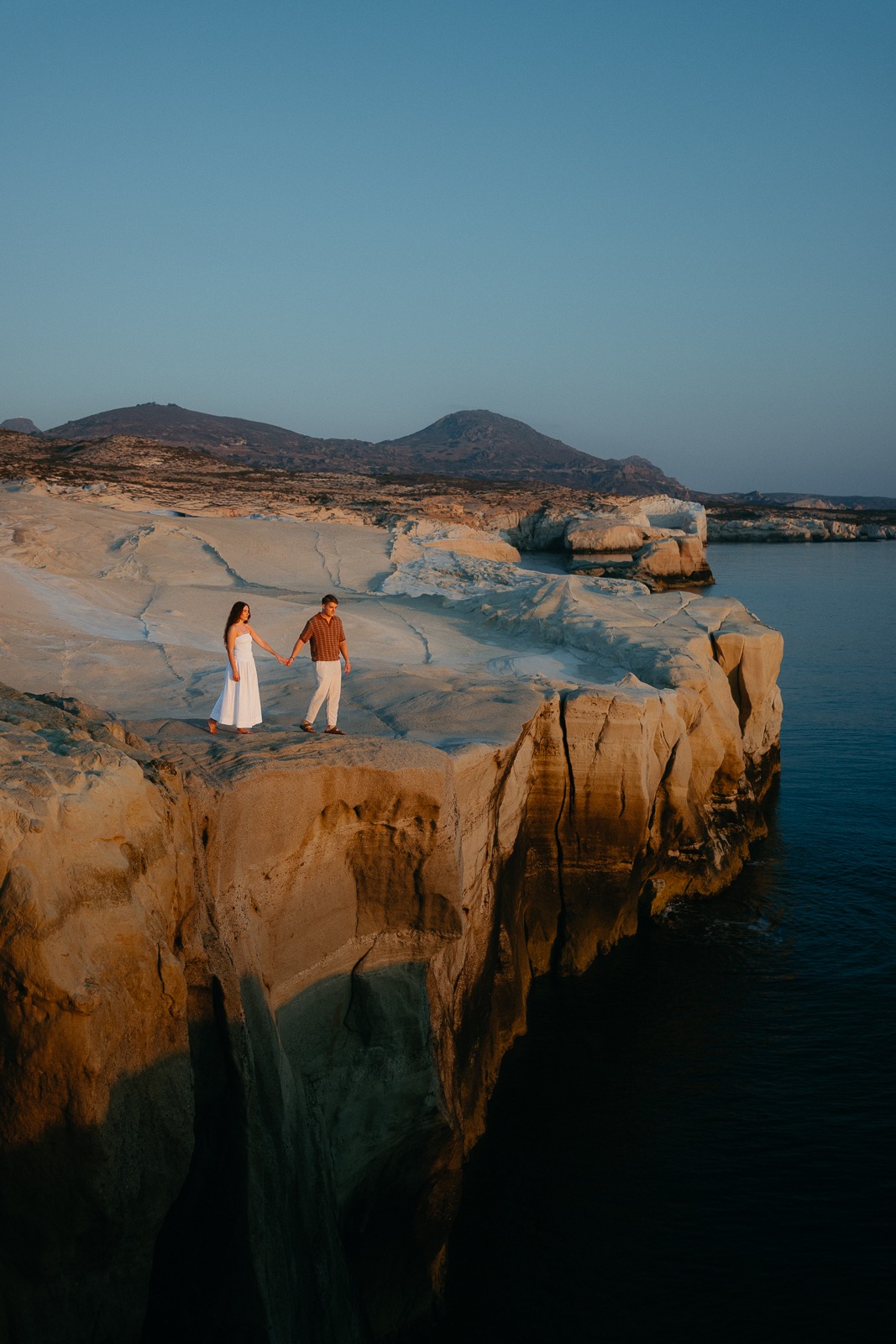 Couple at sunrise on Sarakiniko beach, photographed by a Milos photographer